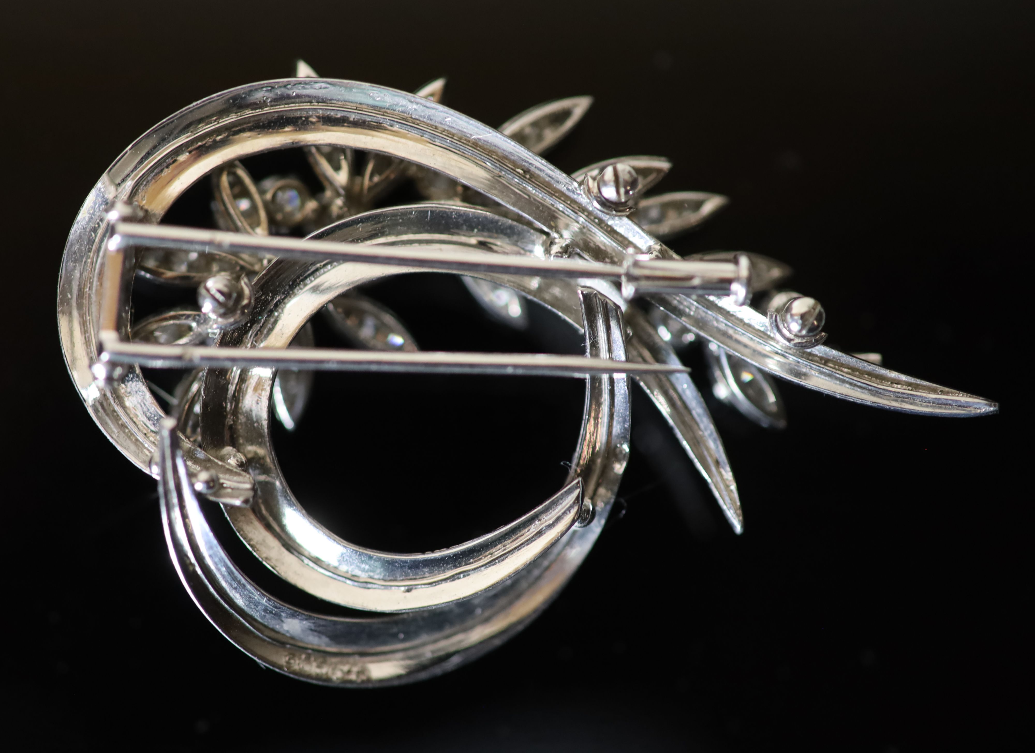A mid 20th century French 18ct white gold and diamond set foliate scroll clip brooch,